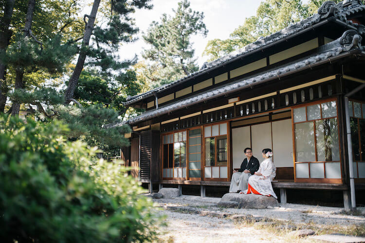 鶴舞公園のお茶室の縁側に座っている新郎新婦