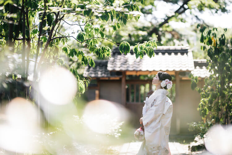 白無垢を着て日本庭園で撮影している新婦