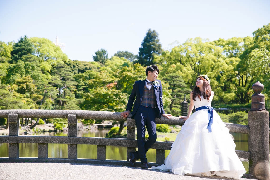 鶴舞公園の橋と池の前で洋装を着て撮った結婚写真