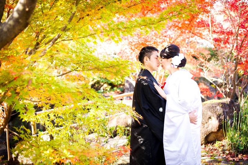 緑、オレンジのキレイな紅葉の前で撮った結婚写真