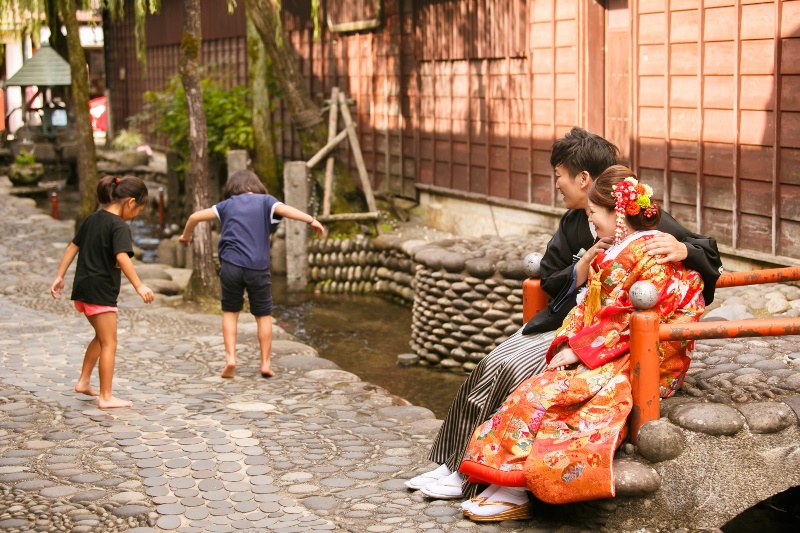 郡上の清流ながれる川の隣で遊んでいる子供達。