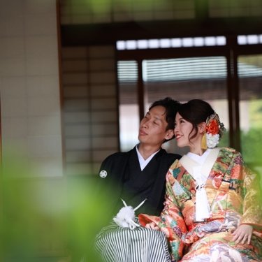 和室の窓辺で寄り添って見つめ合う紋付袴の新郎と色打掛の花嫁。白鳥庭園の茶室で撮る和装前撮り