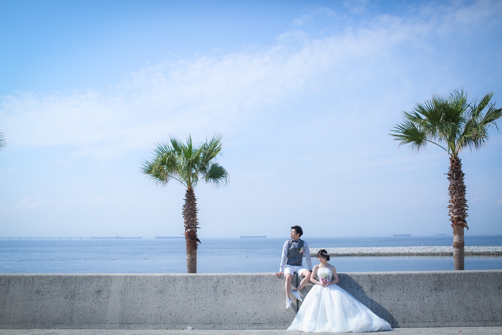 りんくうビーチとヤシの木と新郎新婦