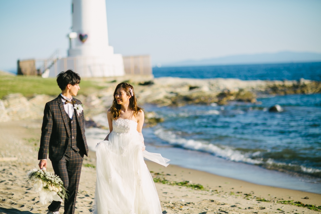 内海のビーチを歩く新郎新婦