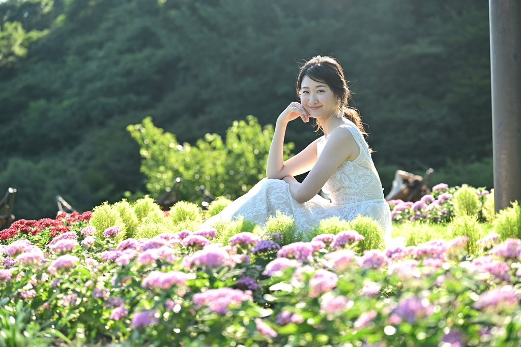 花壇に座って笑顔の花嫁