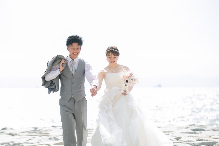 手をつないで笑顔で歩く新郎新婦