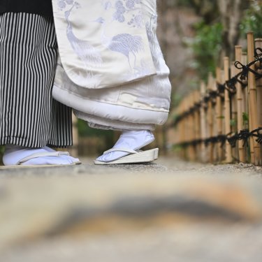 竹垣の小道を並んで歩く新郎新婦の足元。白無垢の裾と袴が並ぶ和装前撮りの足元カット