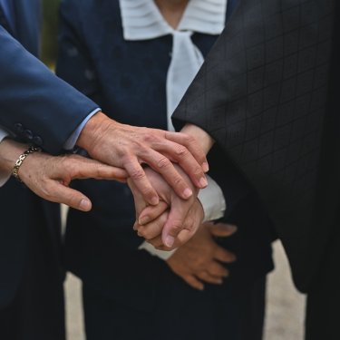 新郎とご両親の手が重なる手元のカット。家族のつながりを感じる和装フォトウェディングの一枚