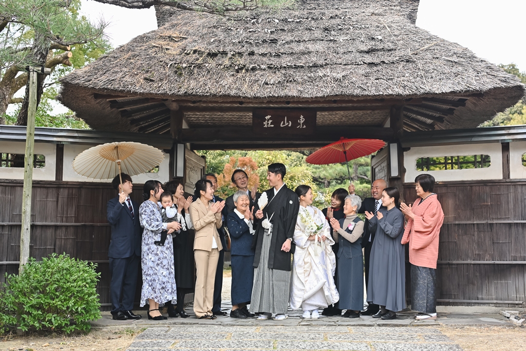 祖父母と孫が手をつないで歩く様子の写真