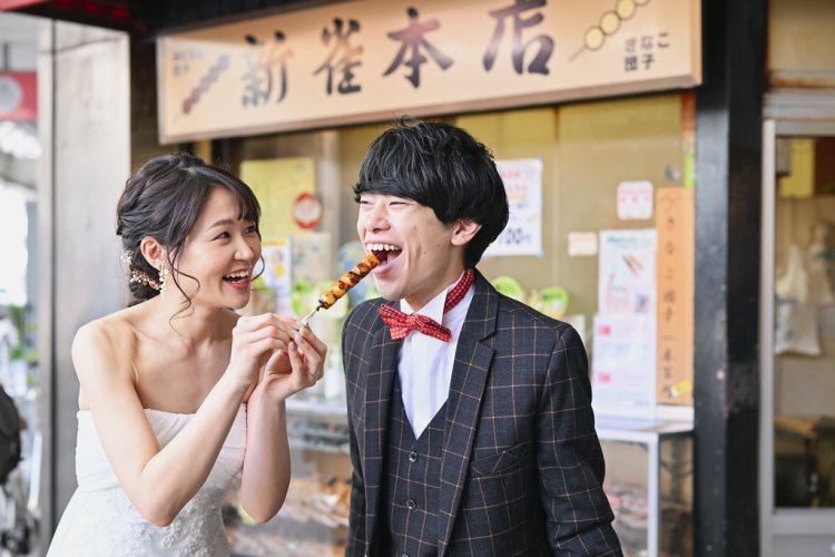 大須の街並みを背景にウェディングドレス姿のカップルが自然な笑顔で寄り添っている前撮り写真