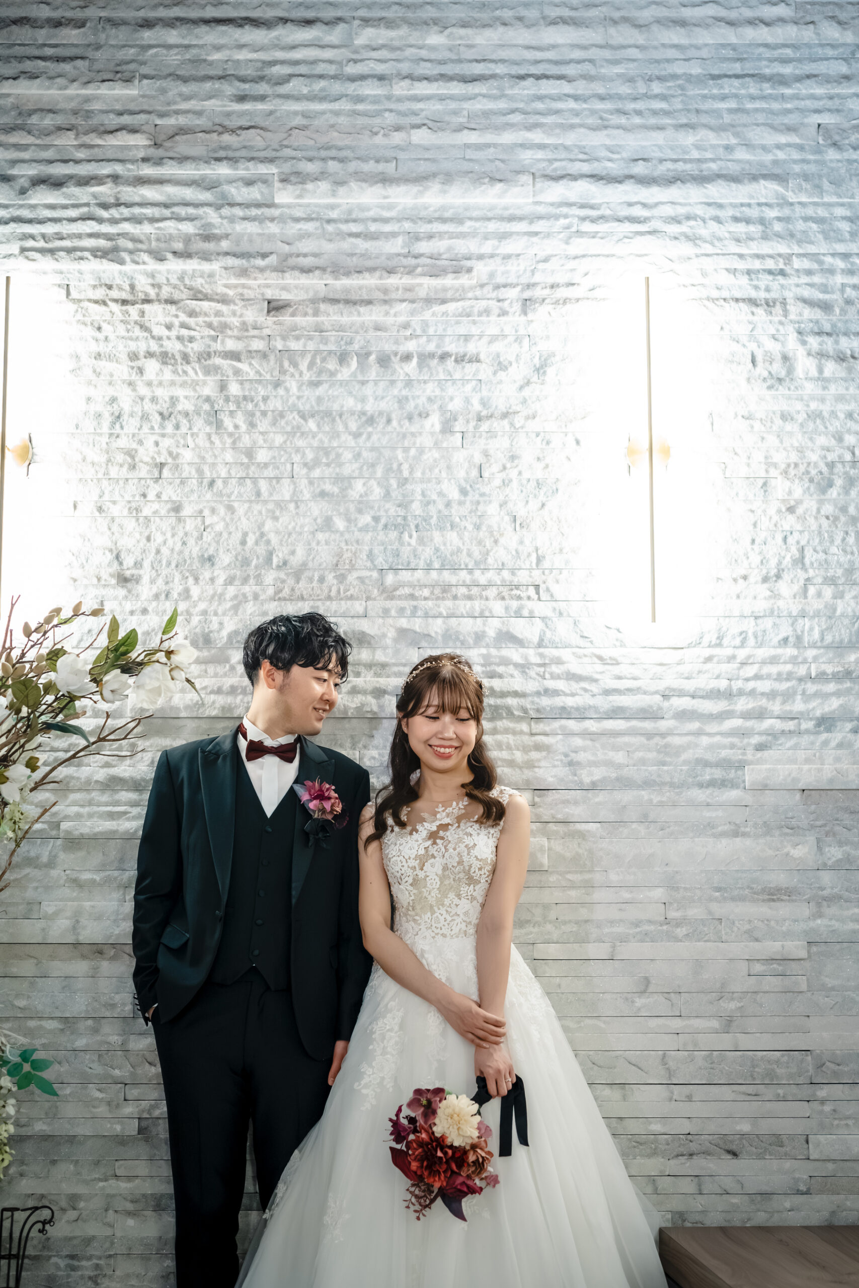 エンジェルストーンの壁を背にした新郎新婦