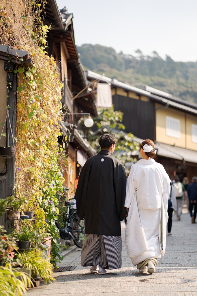 京都の街並みを背景に和装で前撮り撮影をするカップル