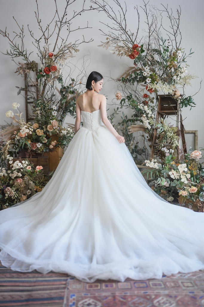 WEDDING AVE.のスタジオでスタッフとドレス選びのカウンセリングをしているカップル