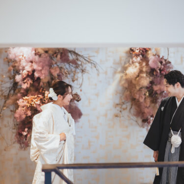 振り返った紋付袴の新郎と、ほほえむ白無垢の花嫁が対面するファーストミートの和装スタジオフォト