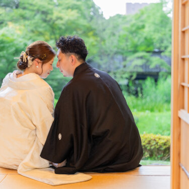 茶室の戸口に並んで座り、庭を前におでこを寄せる新郎新婦の後ろ姿。宗節庵で撮った白無垢の和装前撮り