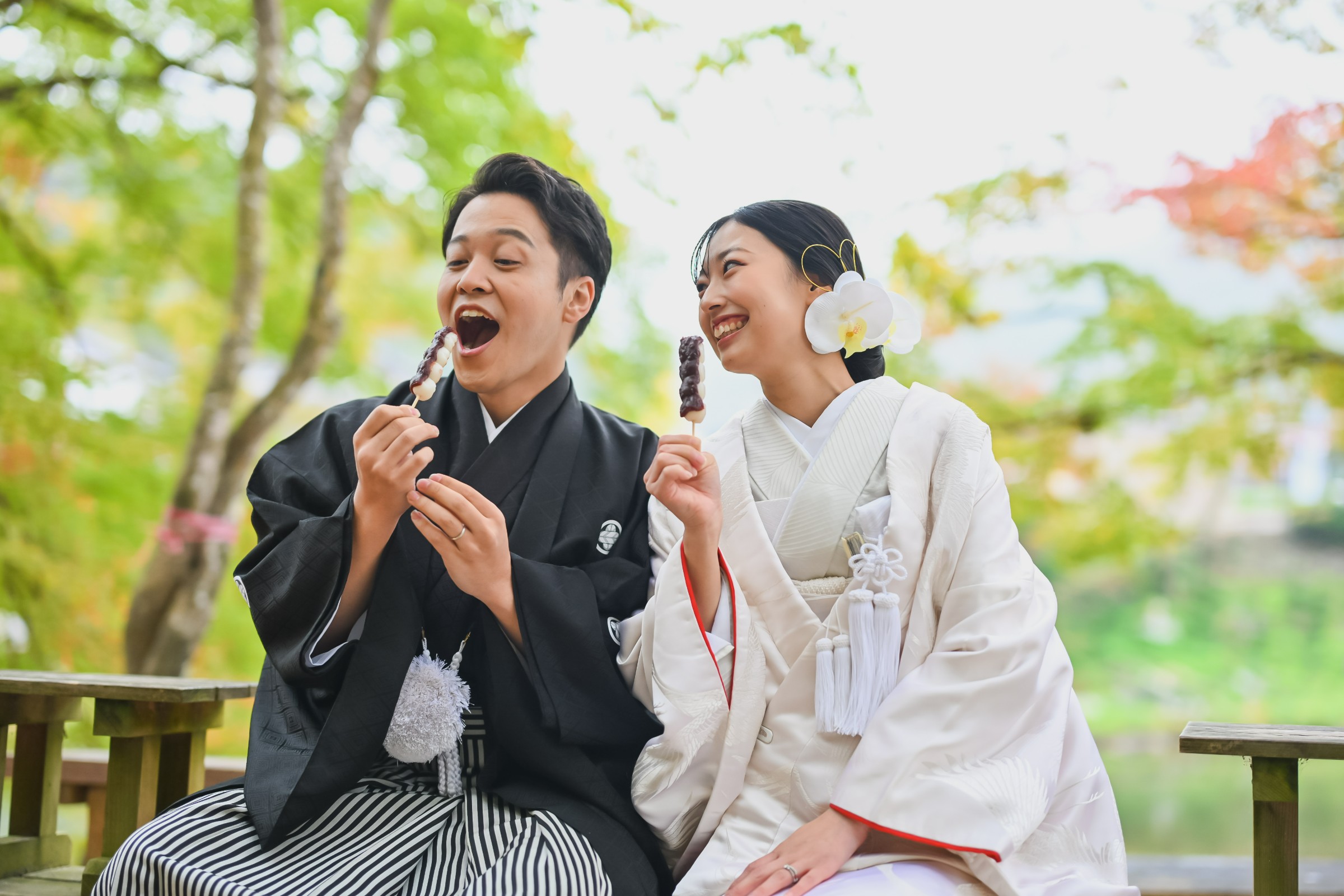 みたらし団子を手に笑い合う新郎新婦、黒紋付袴の新郎と白無垢姿の新婦、香嵐渓での楽しい前撮り。