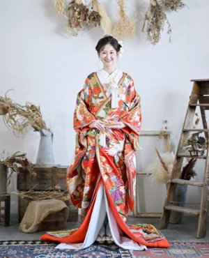 NR03 煌翔のウェディングドレス。鮮やかな赤地に映える、色とりどりの重ね襟が印象的な一着。華やかな彩りが奥行きと立体感を生み、伝統美の中にモダンなセンスを添えます。