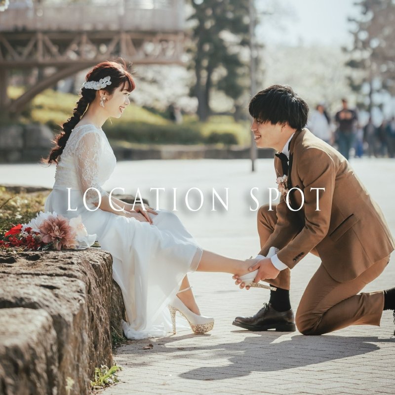 「LOCATION SPOT」案内バナー、桜の名所で新婦の靴を新郎が跪いて結ぶロケーションフォト